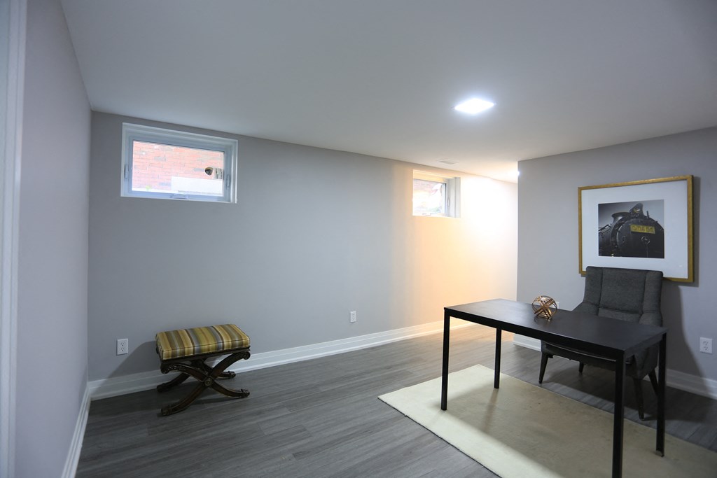 a living room with a desk and a chair and a window
