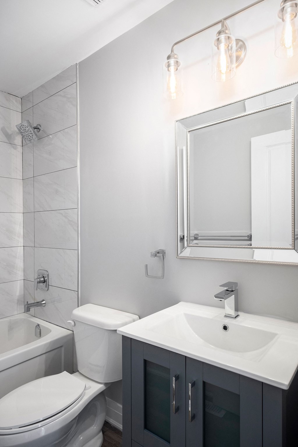 a white bathroom with a sink toilet and mirror
