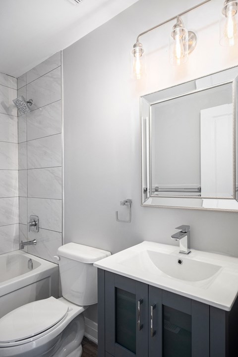 a white bathroom with a sink toilet and mirror
