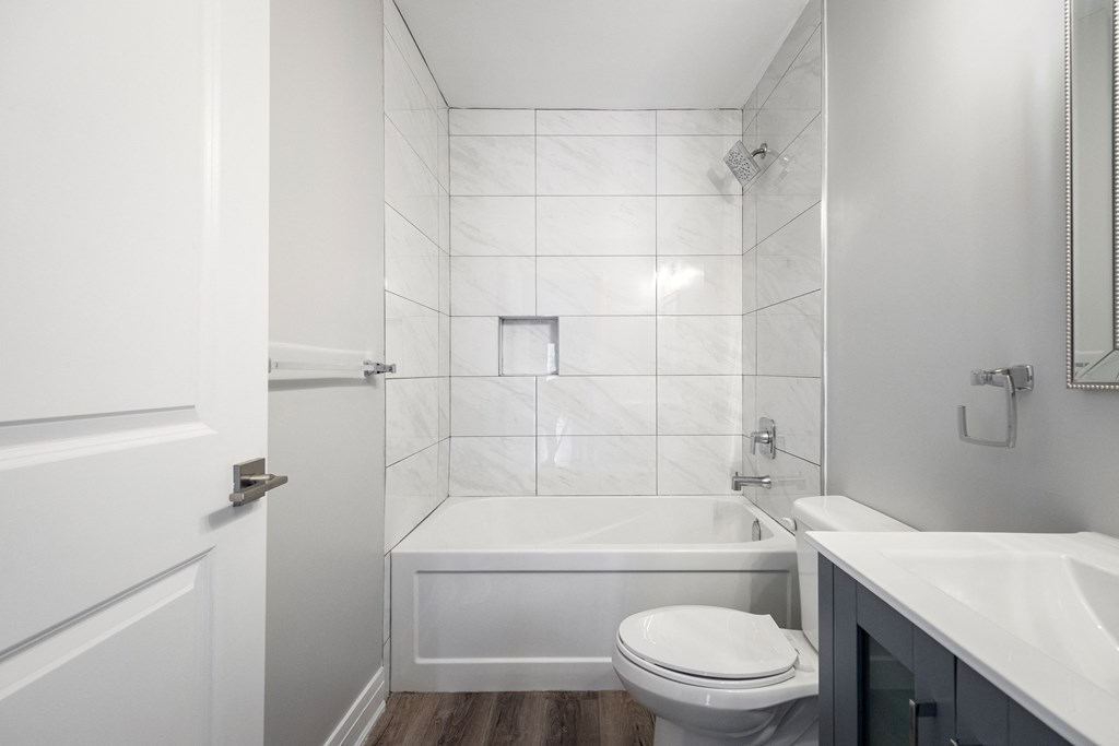a white bathroom with a toilet and a tub and a sink
