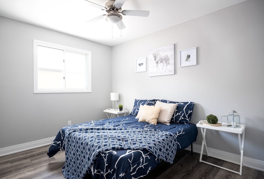 a bedroom with a bed and a ceiling fan