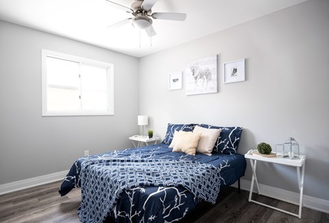 a bedroom with a bed and a ceiling fan