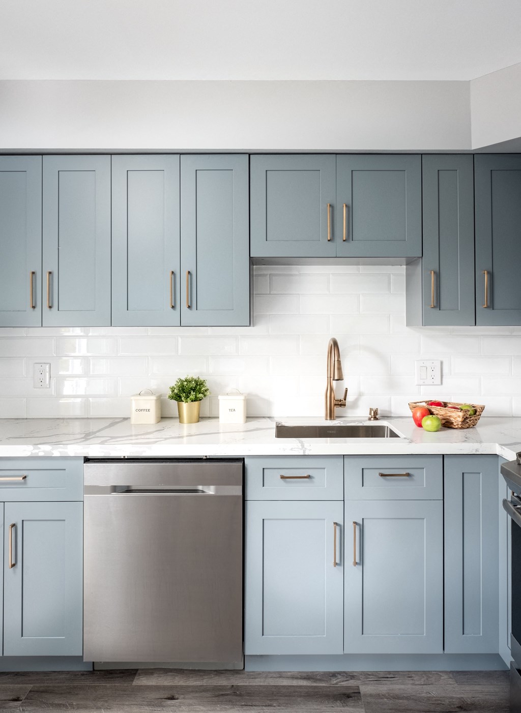 a kitchen with blue cabinets and white countertops and a sink