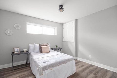 a bedroom with grey walls and a bed with white sheets and pillows