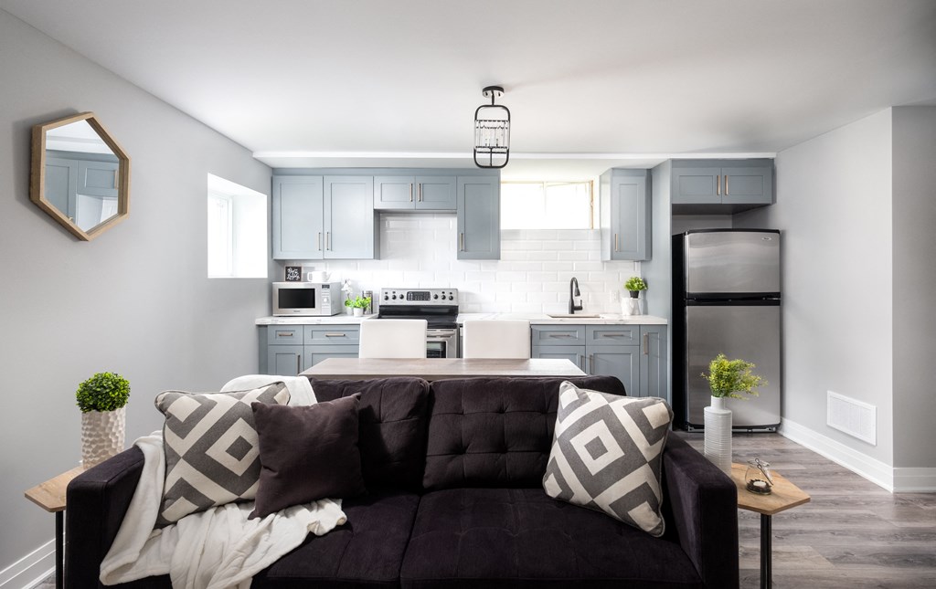 a living room with a couch in front of a kitchen