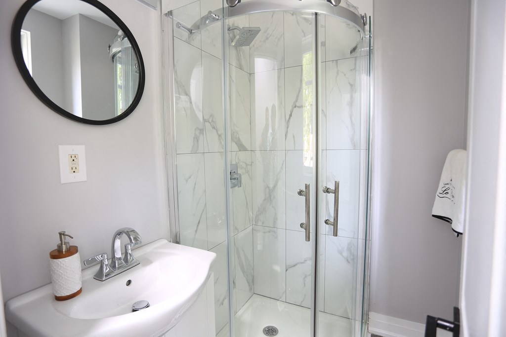 a bathroom with a shower and a sink and a mirror