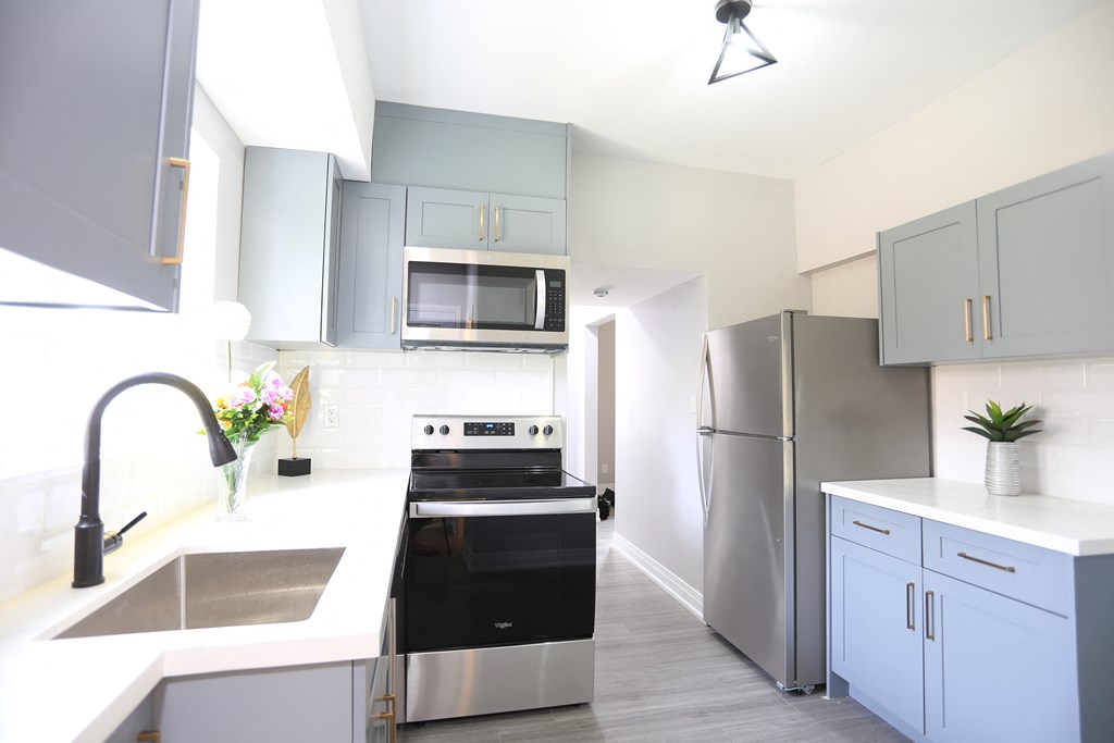 a modern kitchen with stainless steel appliances and white counter tops