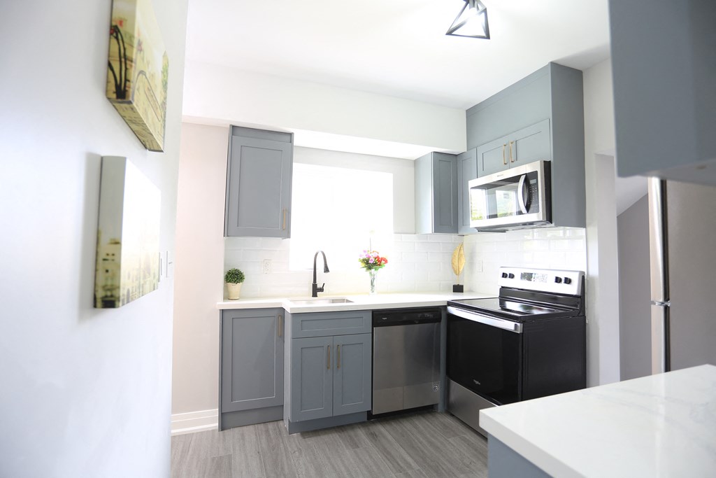 a small kitchen with black appliances and gray cabinets