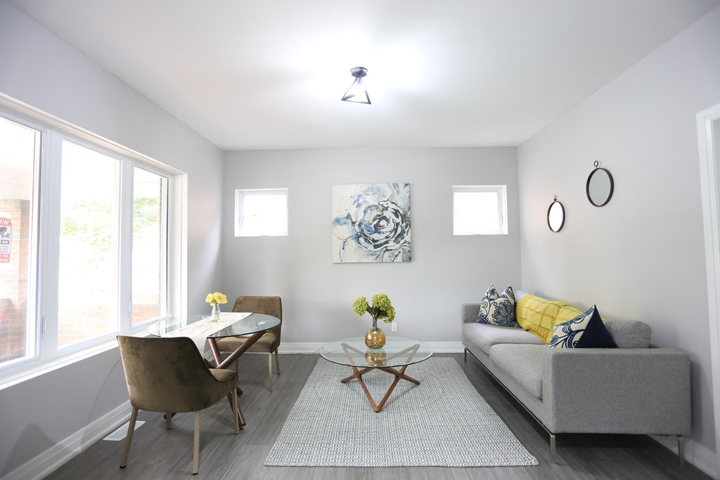 a living room with a couch and two chairs and a table