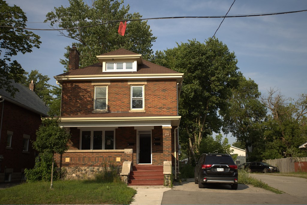 a brick house with a black car parked in front of it