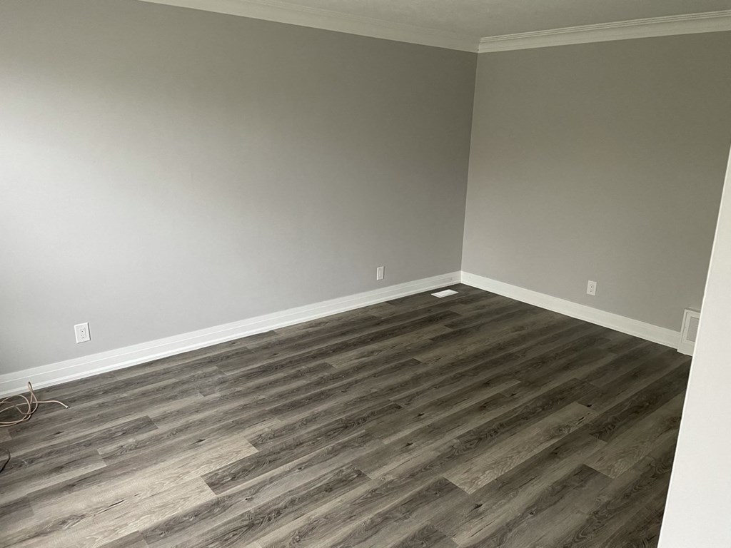 a empty room with wooden floors and grey walls