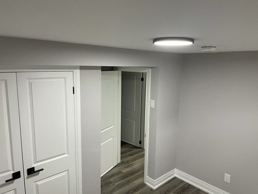 a hallway with white doors and a door to a closet