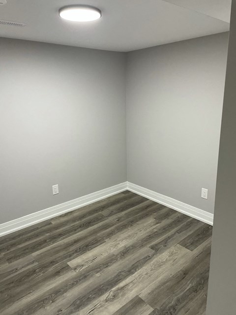an empty room with wood floors and white walls
