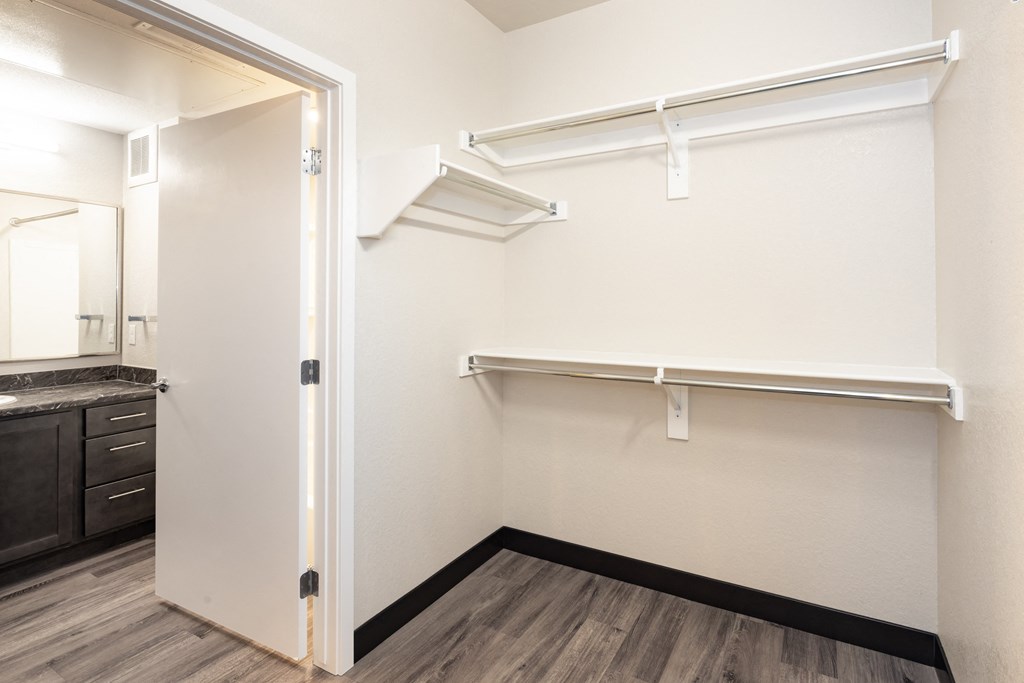 A white closet with a shelf and a mirror.
