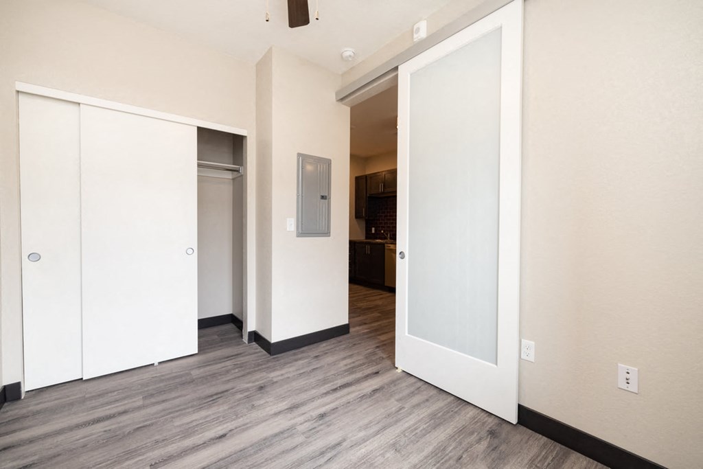 a view of a living room with white walls and wood floors
