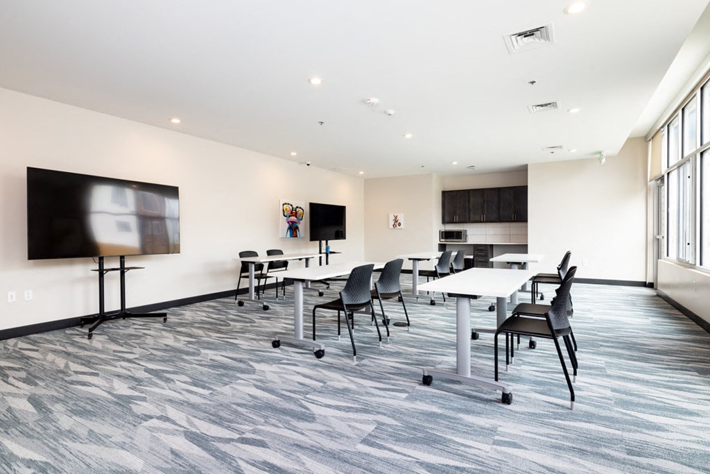 a conference room with tables and chairs and a tv