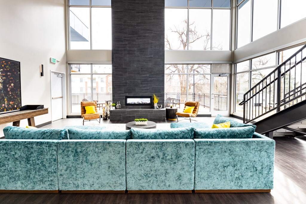 a large living room with a blue couch and a fireplace