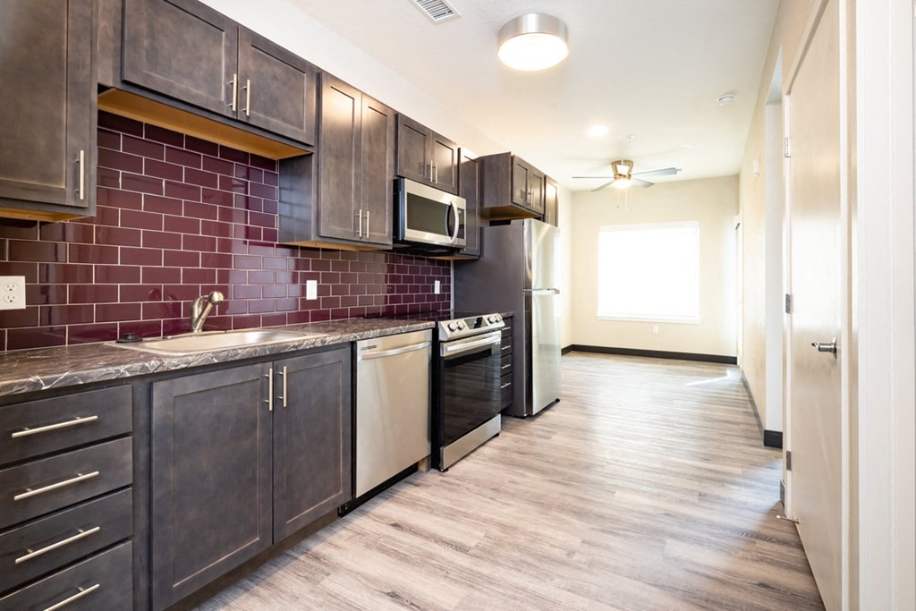 a kitchen with dark cabinets and a sink and a microwave