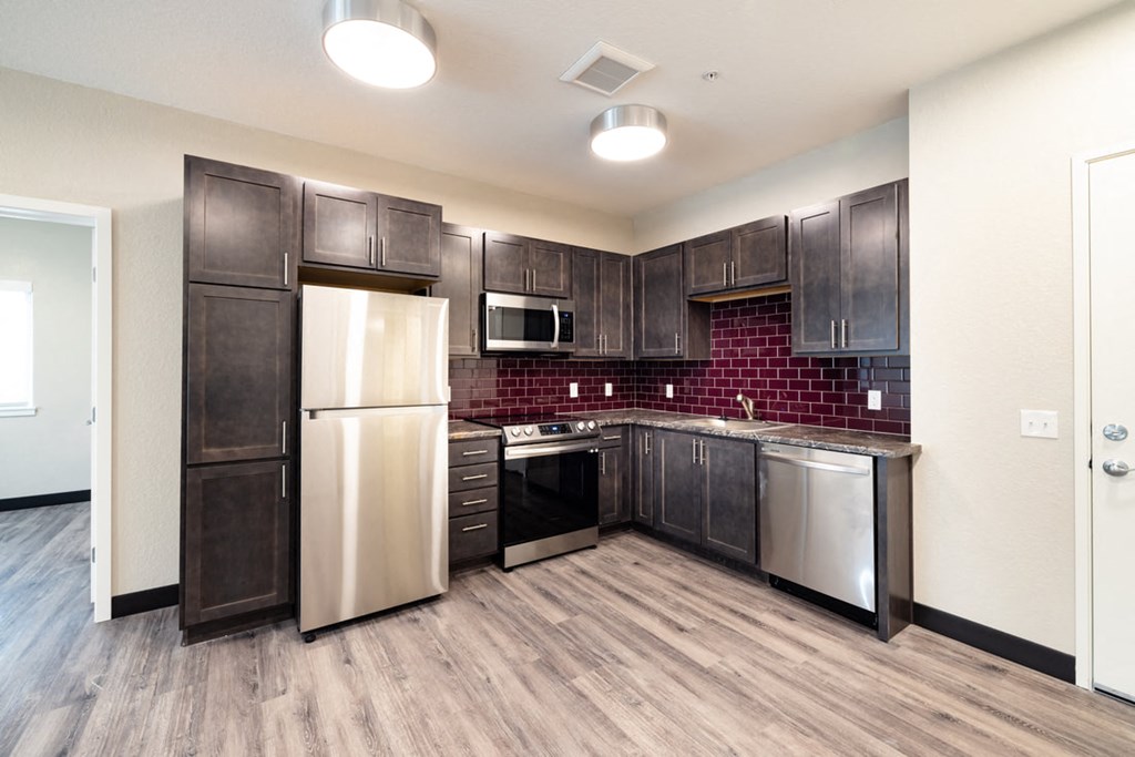 a kitchen with stainless steel appliances and dark wood cabinets