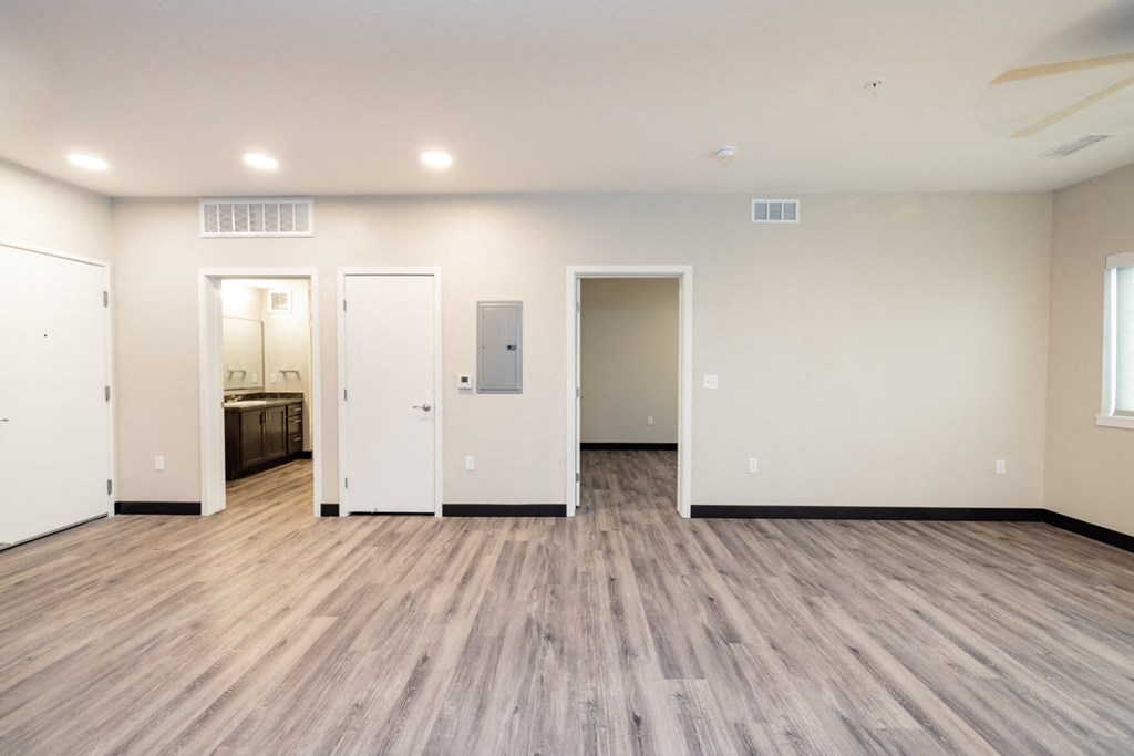 the living room of a new home with white walls and wood floors