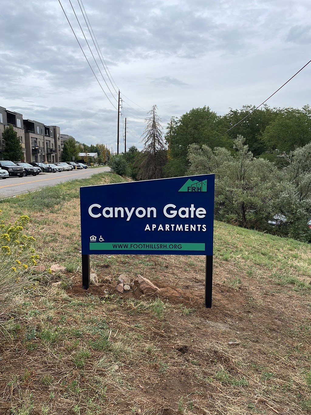 a sign for canyon gate apartments on the side of a road