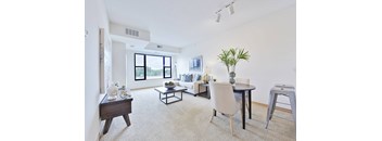 A living room with a white couch, a black coffee table, and a white chair.