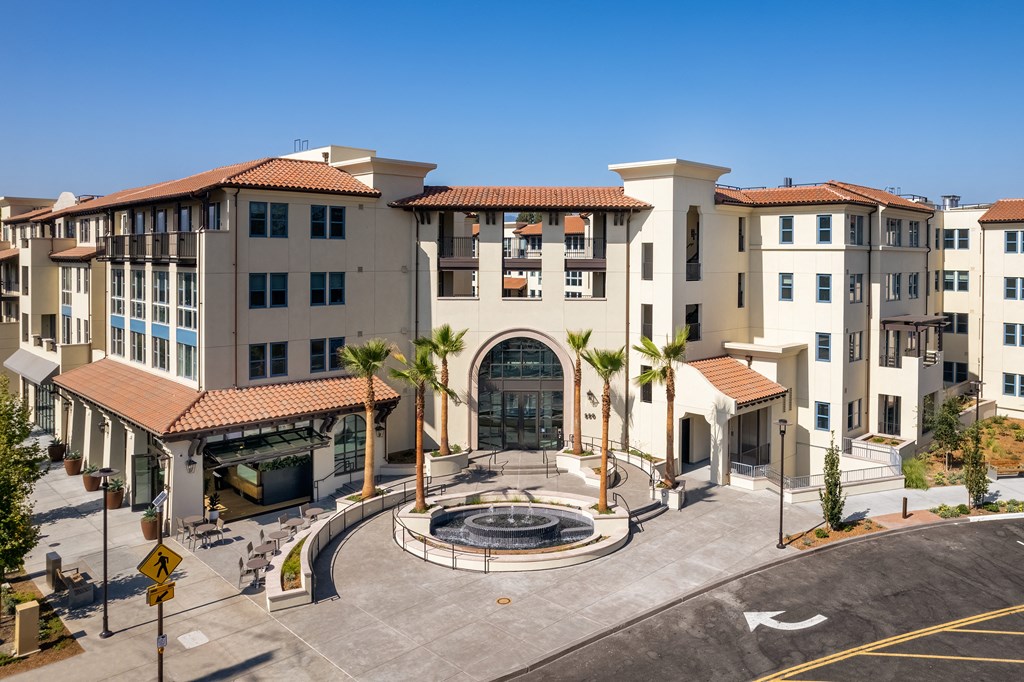 residential entry with fountain and palm trees