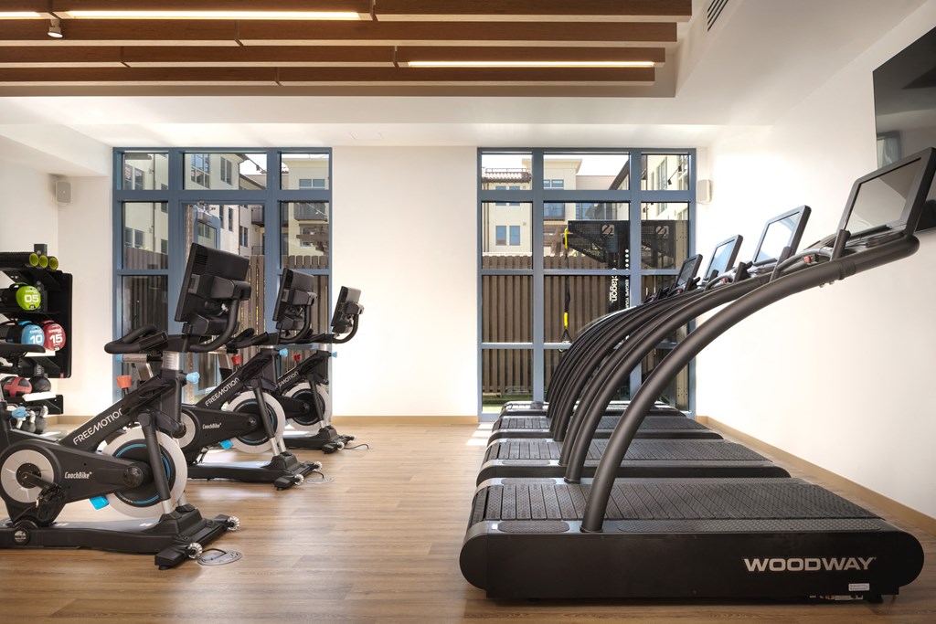gym with treadmills and floor to ceiling windows