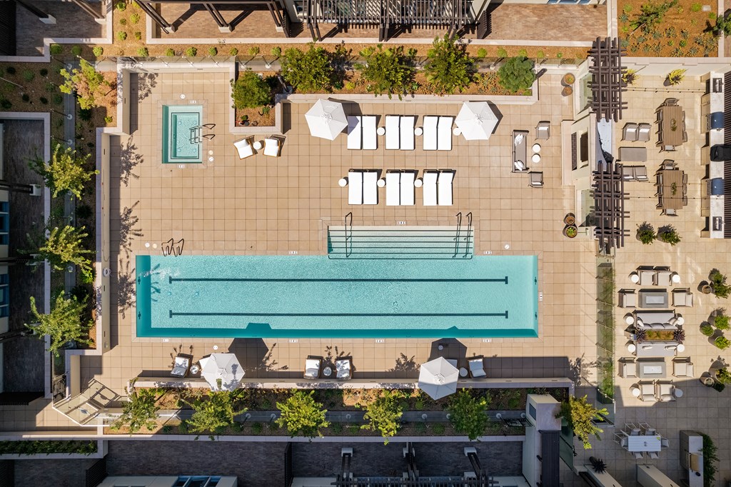 lap pool and hot tub surrounded by lounge chairs