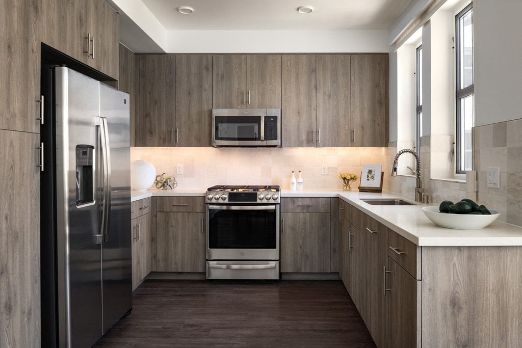 Kitchen with stainless appliances, wood cabinets and floor to ceiling windows
