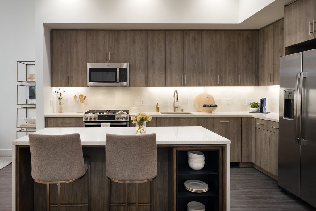 Kitchen with stainless appliances, wood cabinets and floor to ceiling windows