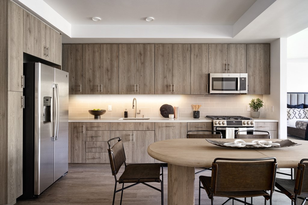 Kitchen with stainless appliances, wood cabinets and floor to ceiling windows