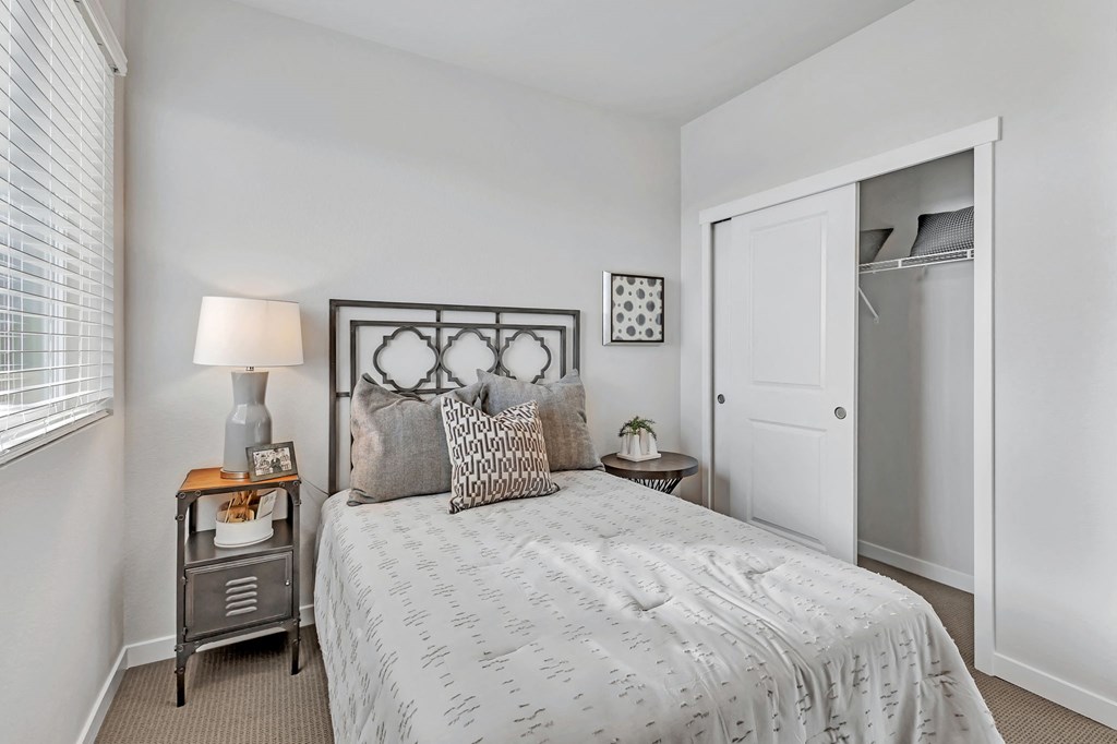 A bedroom with a bed, nightstand, and lamp.