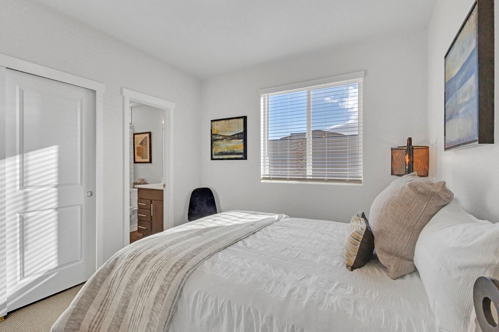 A bedroom with a large bed and a chair.