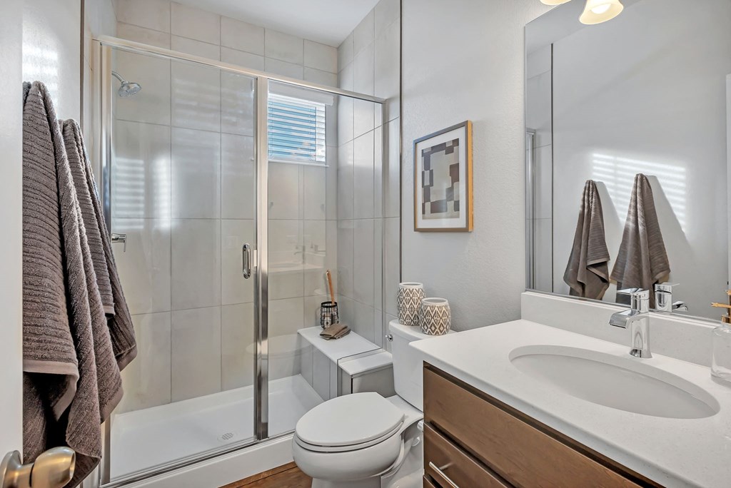 A bathroom with a toilet, sink, and shower.