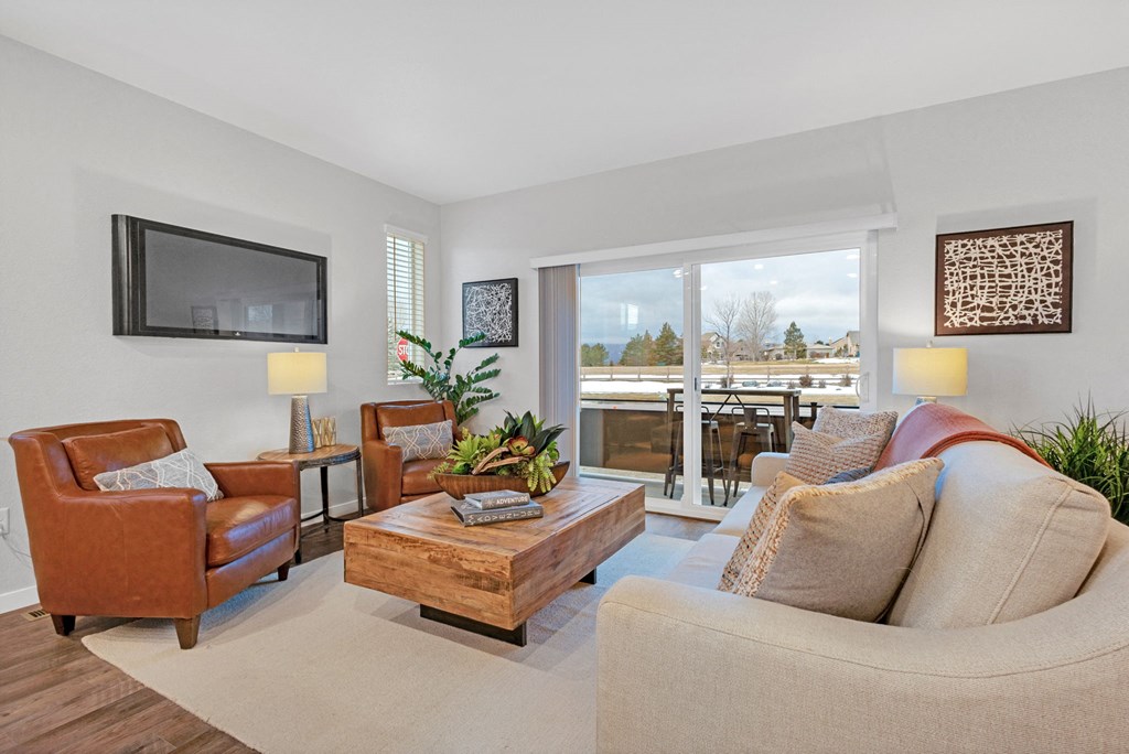 A living room with a brown leather chair, a wooden coffee table, and a beige sofa.