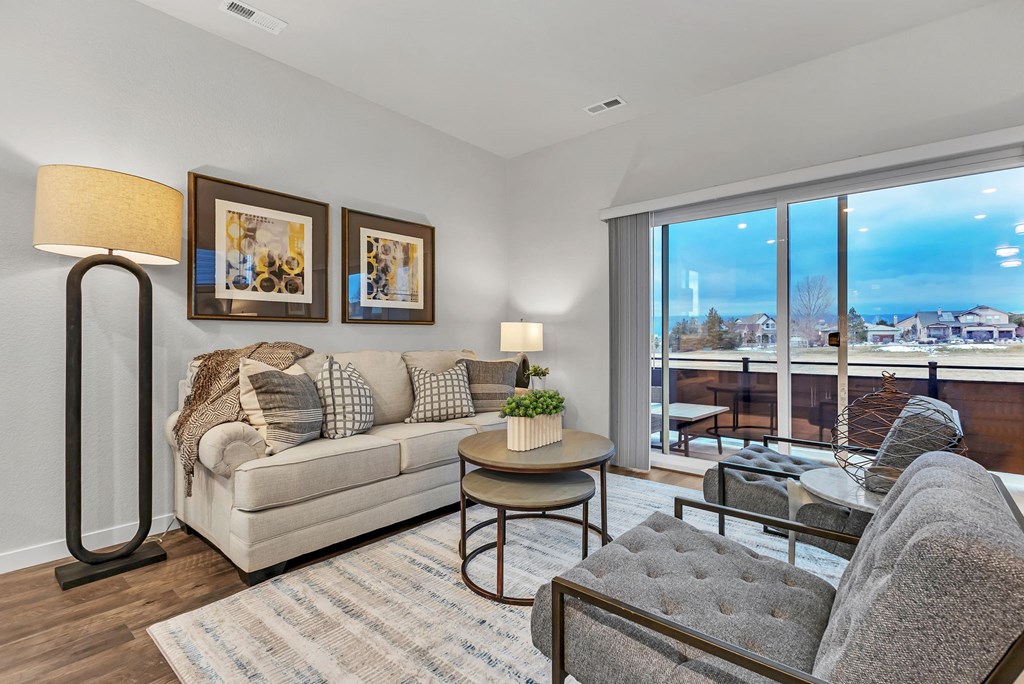 A living room with a couch, a chair, a table, and a floor lamp.