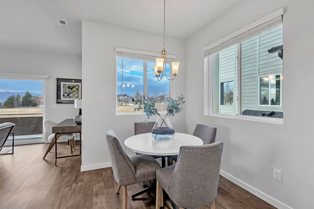 A dining room with a table set for four.