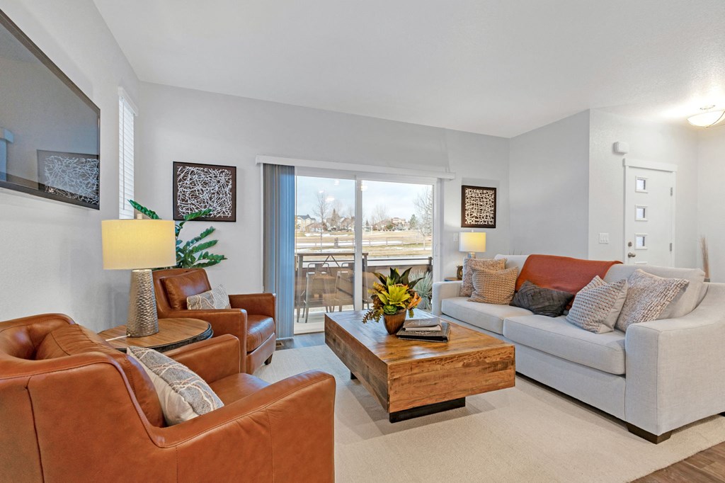A living room with a brown leather chair and a white couch.