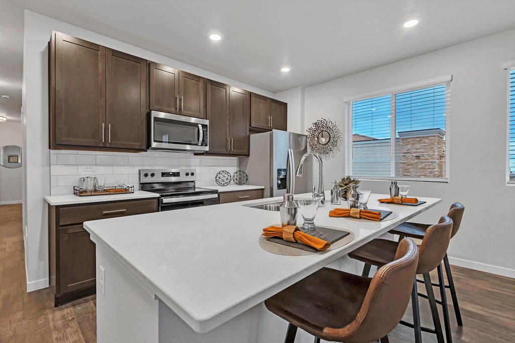 A kitchen with brown cabinets and a white island.