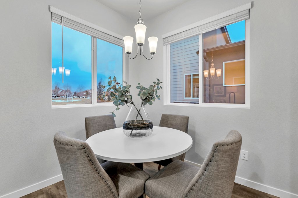 A dining room with a white table and chairs.