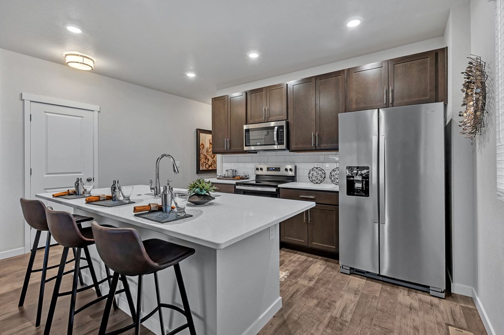 A modern kitchen with a white countertop and a stainless steel refrigerator.