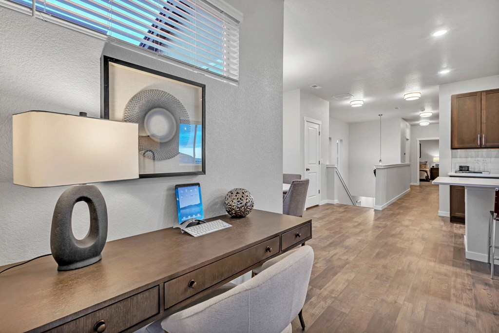 A modern home office with a wooden desk and a laptop.