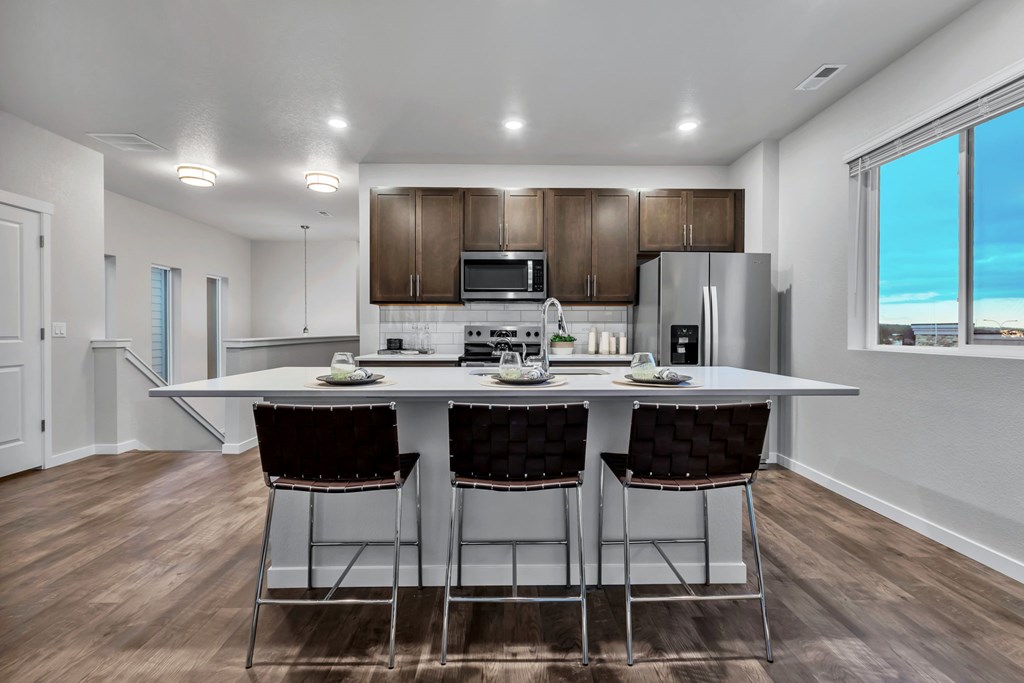 A modern kitchen with a dining table and chairs.