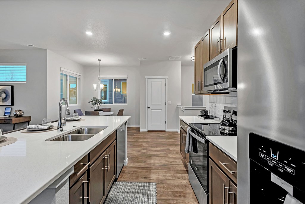 A modern kitchen with stainless steel appliances and wooden cabinets.