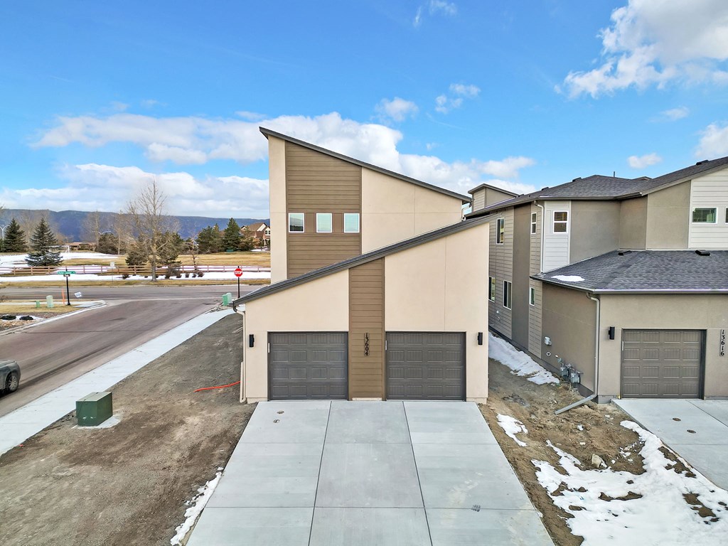 A row of houses with garages and driveways.