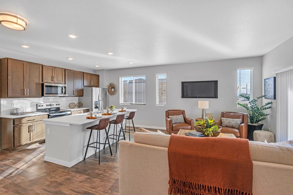 A modern kitchen with a breakfast bar and a couch with a blanket on it.