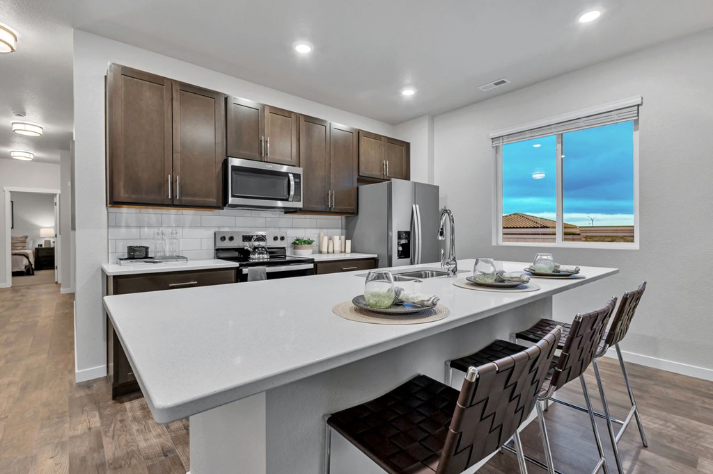 A modern kitchen with a large island and a view of the beach.