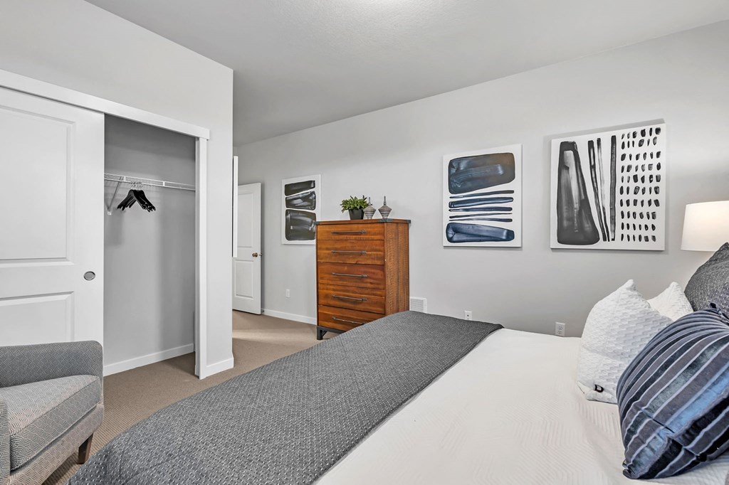 A bedroom with a bed, a dresser, and a couch.