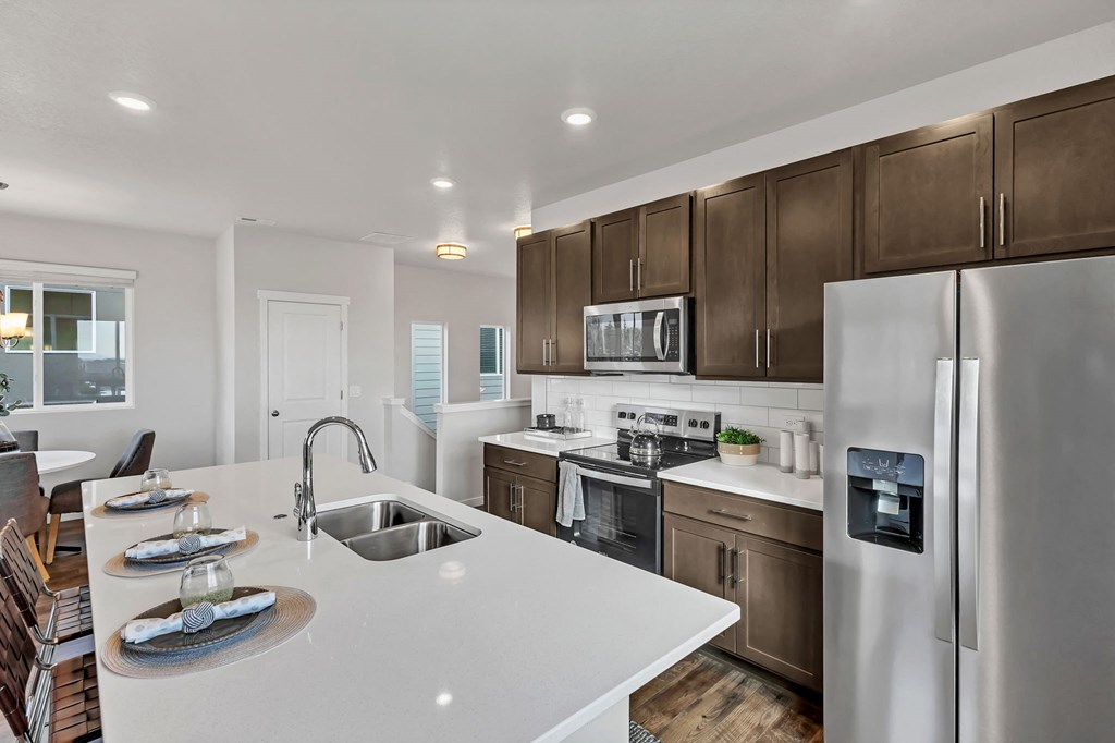 A modern kitchen with a white countertop and stainless steel appliances.